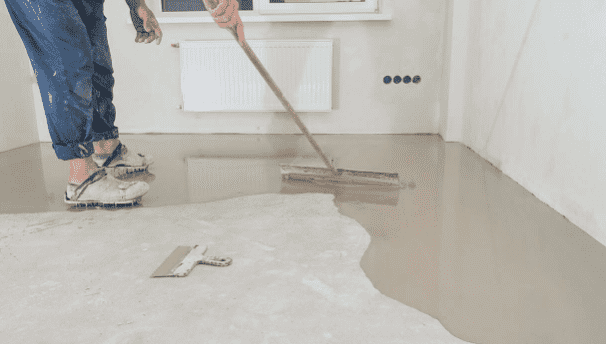 a person painting a concrete floor first coat